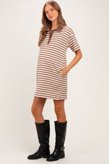 woman wearing a brown and cream striped maternity polo dress with pockets and black knee-high boots, showcasing a baby bump