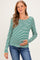 woman wearing a green and white striped long sleeve maternity top and holding her baby bump