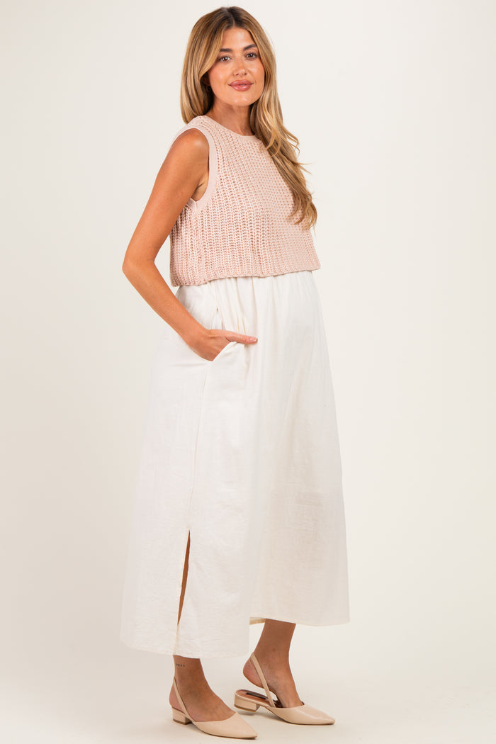 woman wearing a light pink cropped knitted top and a white maternity maxi skirt with side slits and pockets