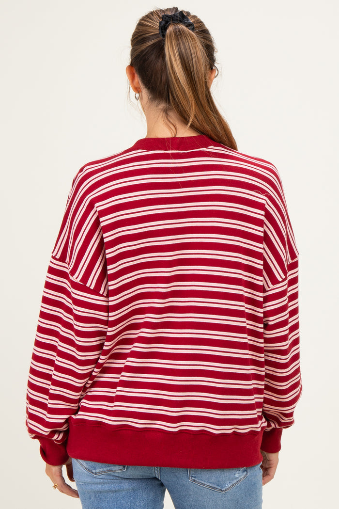 woman wearing a red and white striped maternity sweatshirt, showing the back view and relaxed fit