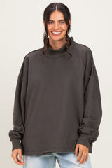 woman wearing a loose-fitting charcoal gray long sleeve mock neck sweatshirt with dropped shoulders