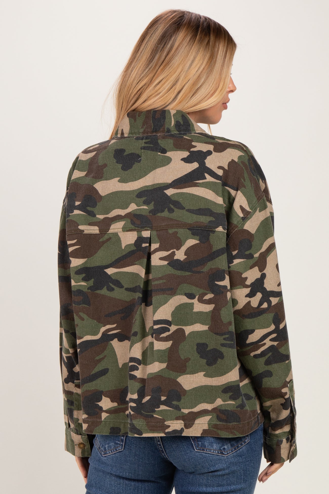 woman wearing a green camouflage jacket, seen from the back, with a relaxed fit and a collar