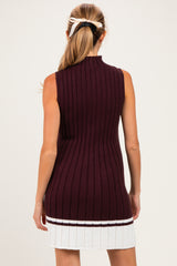 woman wearing a sleeveless burgundy knit maternity tunic dress with ribbed texture and white stripe at the hem