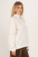woman wearing a cream floral print sweatshirt with a mock neck and oversized fit