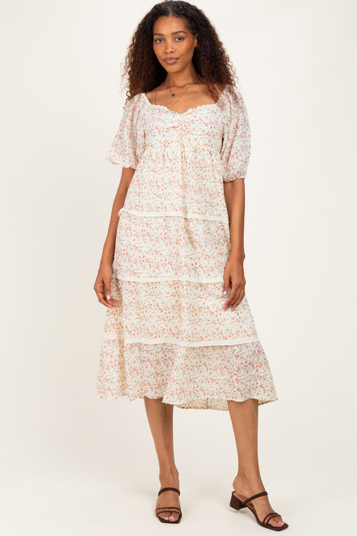 woman wearing a white floral tiered midi dress with puff sleeves and a ruffled hem