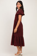 woman wearing a burgundy polka dot midi dress with puff sleeves and a ruffled hem