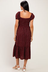 woman wearing a burgundy polka dot midi dress with puff sleeves and a tiered hem, shown from the back