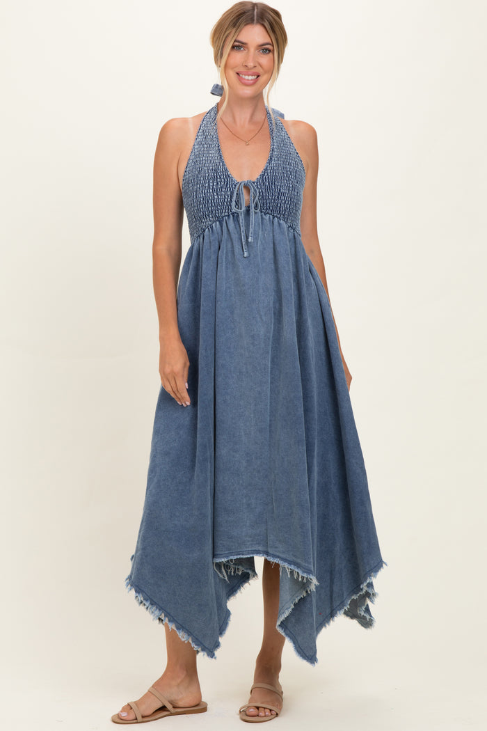woman wearing a denim halter-style maxi dress with a smocked bodice and frayed hemline