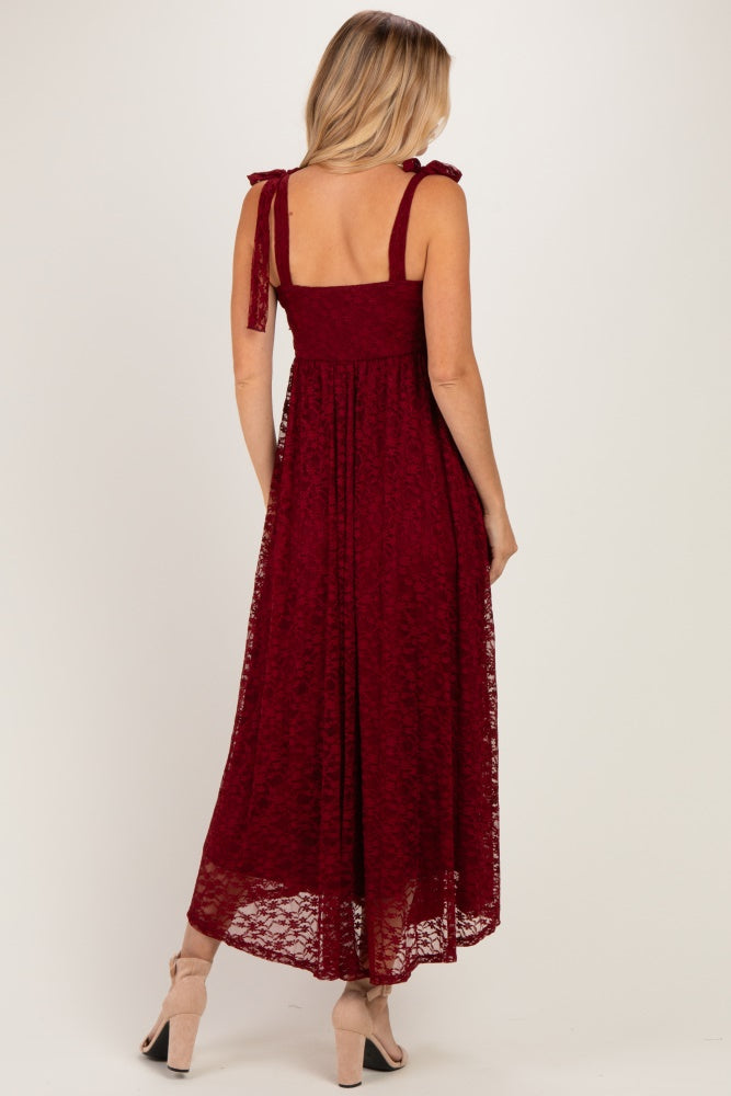 woman wearing a burgundy lace maxi dress with tie straps and a flowy skirt, shown from the back