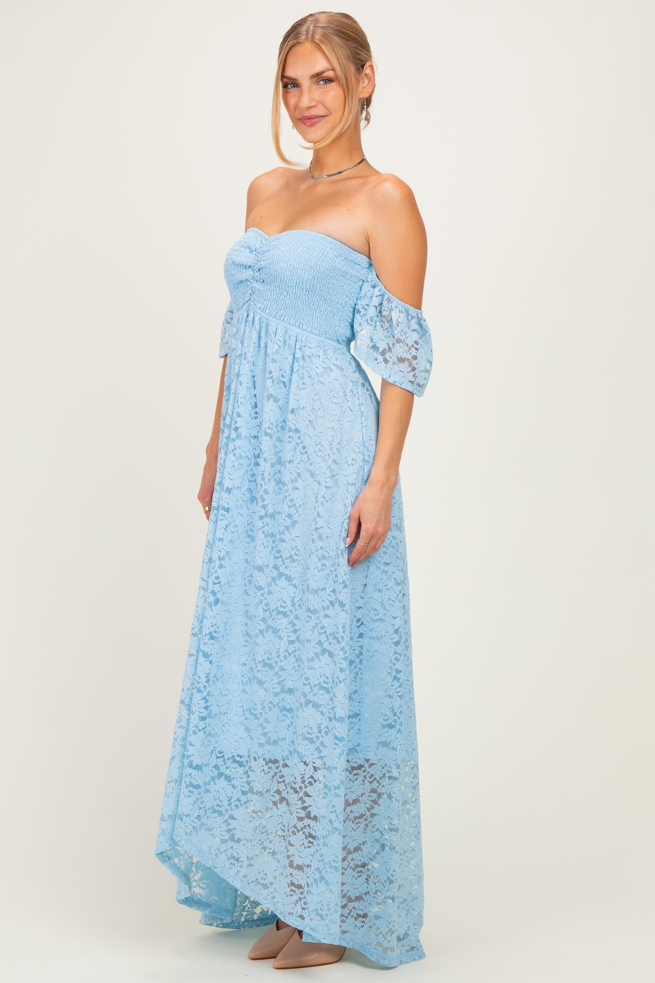woman wearing a light blue off-the-shoulder lace maxi dress with short puff sleeves and a fitted bodice