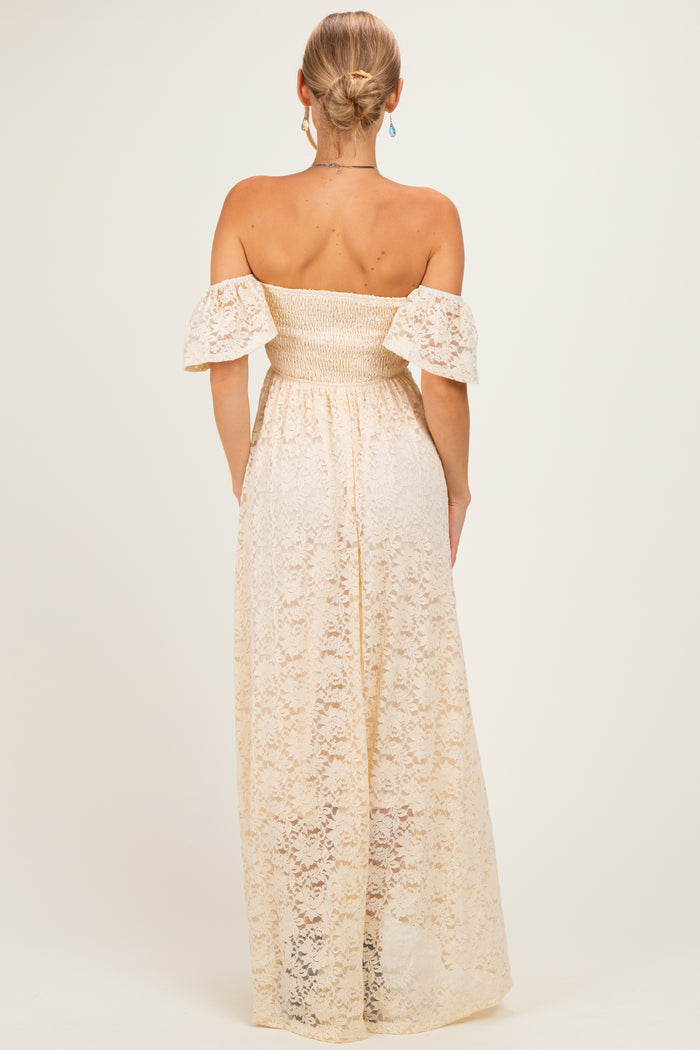 woman wearing a back view of a cream off-the-shoulder maxi dress with lace detailing and puff sleeves