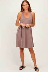 woman wearing a ribbed brown sleeveless dress with a scoop neckline and a flared skirt