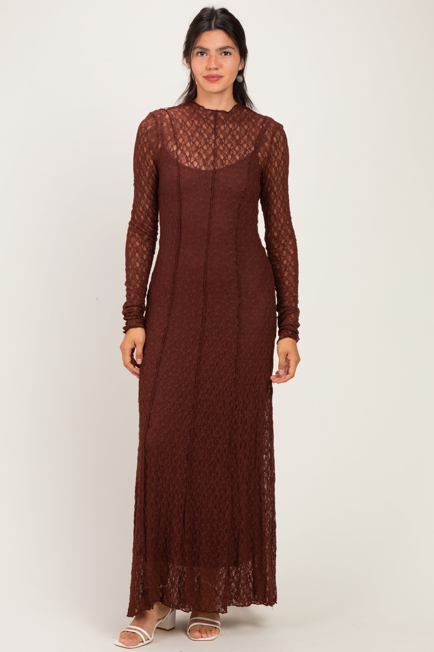 woman wearing a long sleeve brown lace dress with a sheer neckline and fitted silhouette