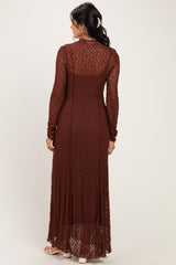 woman wearing a long rust-colored lace maxi dress with long sleeves and a fitted silhouette