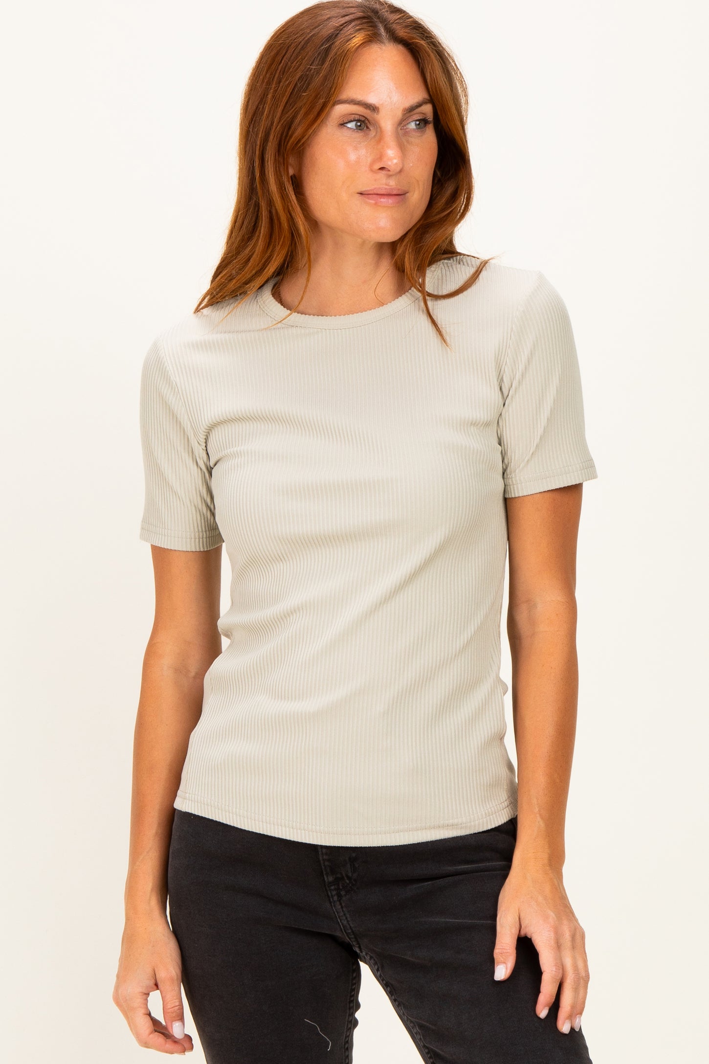 woman wearing a light beige ribbed short sleeve top and black jeans