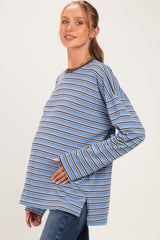 woman wearing a blue and brown striped maternity top and holding her baby bump