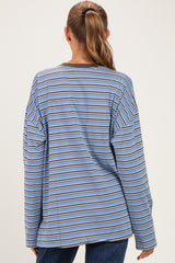 woman wearing a blue and brown striped maternity top with long sleeves, shown from the back
