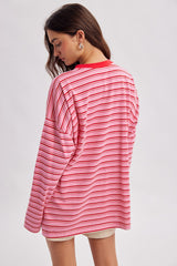 woman wearing a pink and white striped oversized long sleeve shirt with a round neckline