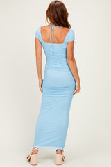 woman wearing a light blue fitted maxi dress with a square back and tie detail at the neck