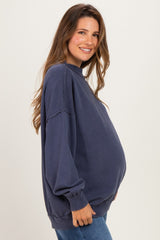 woman wearing a navy oversized maternity sweatshirt with a visible baby bump