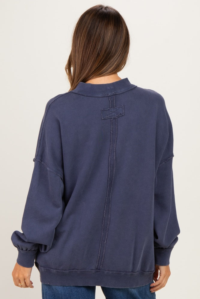 woman wearing a dark navy oversized maternity sweatshirt with a stitched back detail