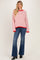 woman wearing a red and white striped oversized sweater with flared jeans and black ankle boots