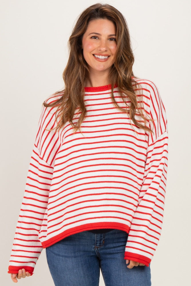 woman wearing a red and white striped oversized maternity sweater with long sleeves