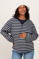 woman wearing a navy and white striped maternity sweatshirt and holding her baby bump