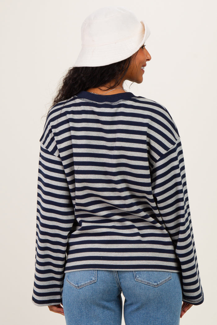 woman wearing a navy and gray striped maternity top with long sleeves and relaxed fit, seen from the back