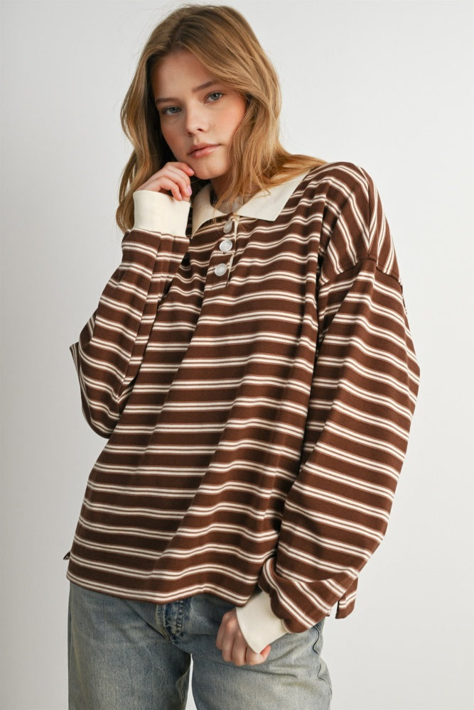 woman wearing a brown and cream striped oversized long sleeve top with a collar and button detail