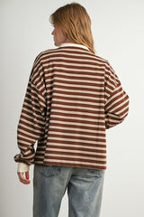 woman wearing a brown and cream striped oversized long sleeve top with a relaxed fit and dropped shoulders