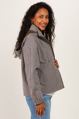 woman wearing a brown and white checked maternity jacket and showing her baby bump