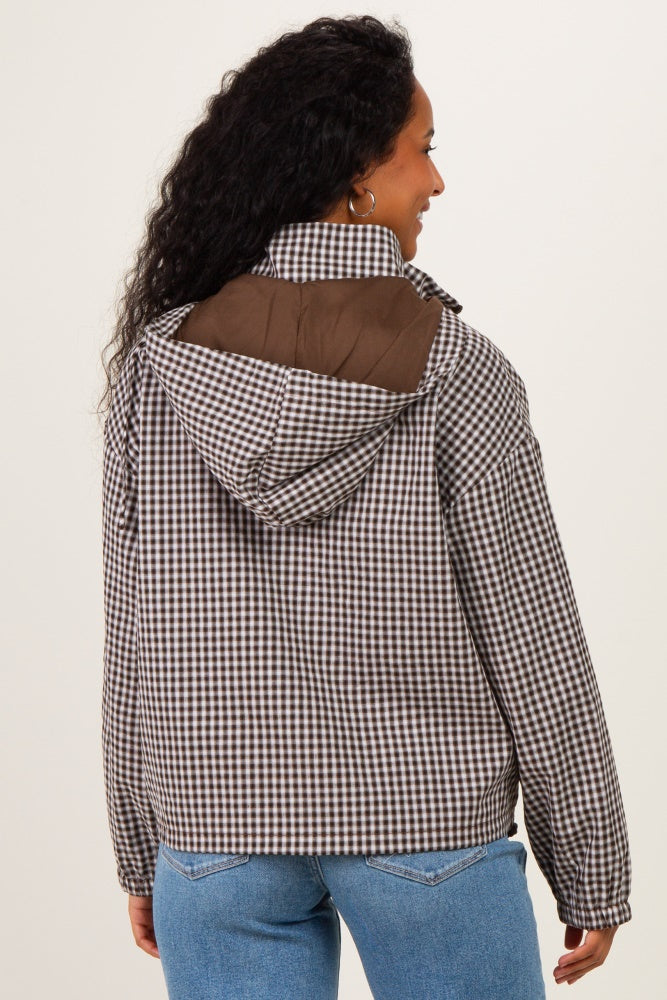 woman wearing a brown and white checkered maternity jacket with a hood, seen from the back