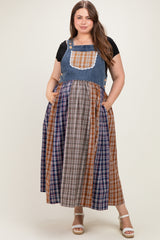plus-size woman wearing a maternity wear plaid overall dress with denim top and long plaid skirt, featuring pockets