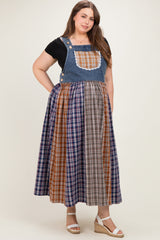 woman wearing a denim maternity plus dress with a plaid skirt and a lace-trimmed bib, no visible baby bump