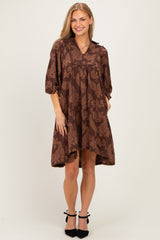 woman wearing a brown paisley print short sleeve dress with a v-neck and slight hi-low hemline
