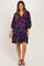 woman wearing a teal maternity dress with large purple floral print and a v-neckline