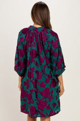 woman wearing a teal and purple floral maternity dress with a loose fit and kimono-style sleeves