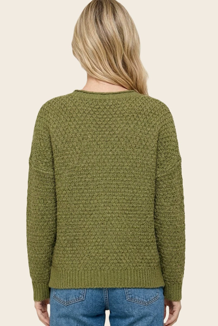woman wearing an olive green textured knit sweater with a relaxed fit, viewed from the back