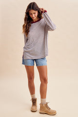 woman wearing a striped long sleeve top with a maroon neckline and denim shorts, paired with tan boots and knee-high socks