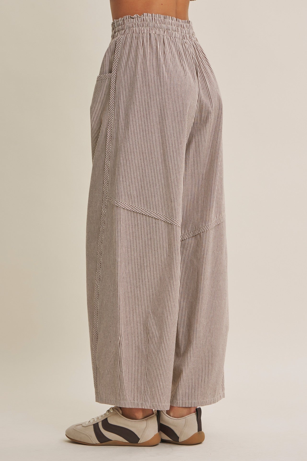 woman wearing loose-fitting striped wide-leg pants with an elastic waistband and side pockets