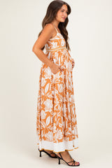 woman wearing a rust floral maternity maxi dress with pockets and a baby bump visible