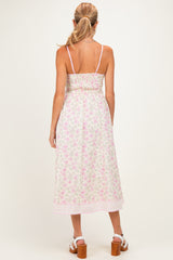 woman wearing a floral maternity dress with adjustable straps and a smocked back, showcasing a relaxed fit