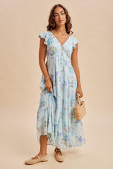 woman wearing a light blue floral maxi dress with flutter sleeves and holding a straw bag