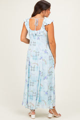 woman wearing a light blue floral print maternity maxi dress with ruffle sleeves and adjustable back tie detail