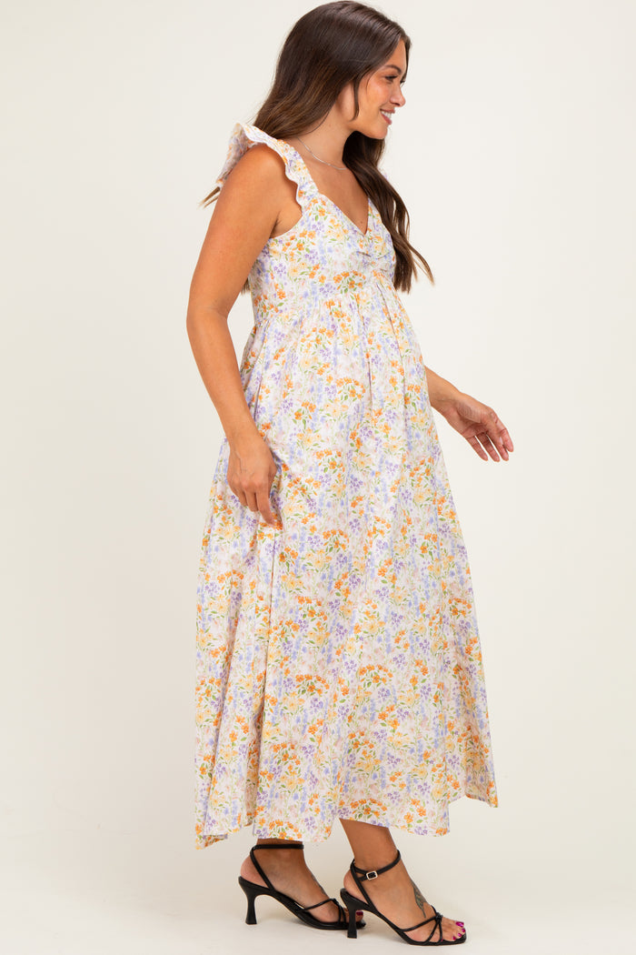 woman wearing a floral maternity maxi dress with ruffle straps and a visible baby bump