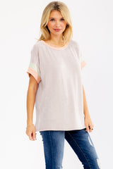woman wearing a striped short sleeve top with pastel color details, paired with blue jeans