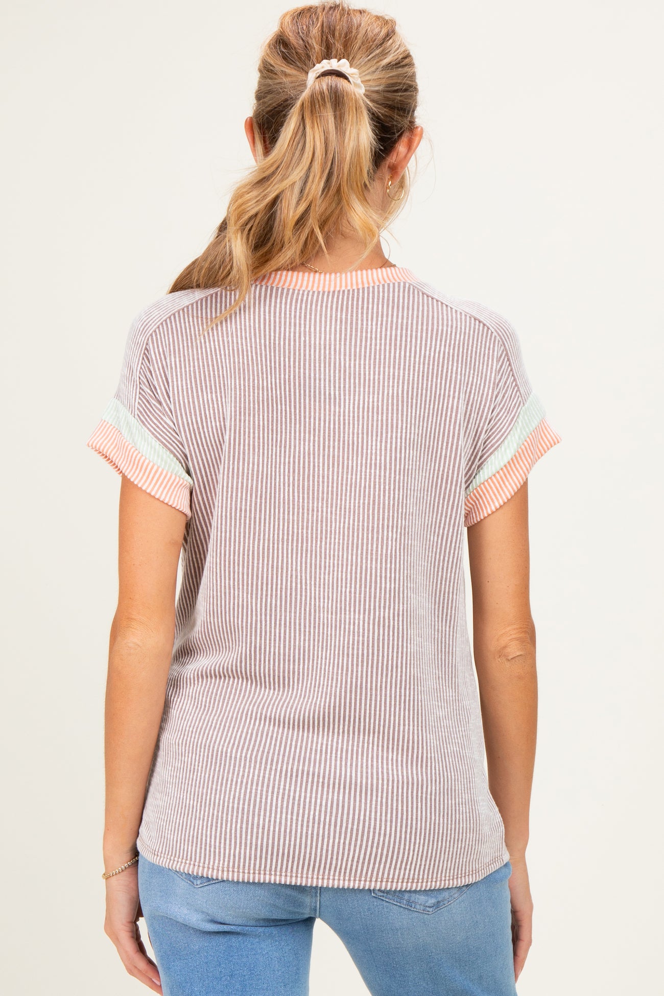 woman wearing a striped maternity top with short sleeves and a relaxed fit, seen from the back