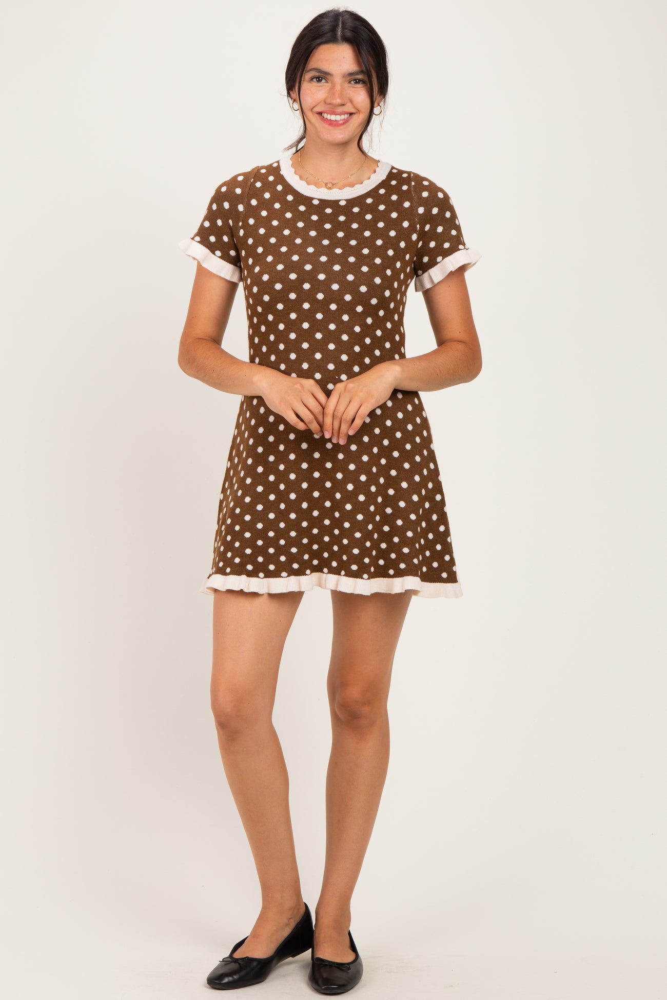 woman wearing a brown polka dot dress with short sleeves and ruffled hem