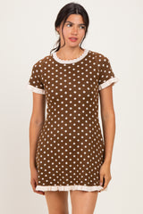 woman wearing a brown polka dot mini dress with white trim and short sleeves